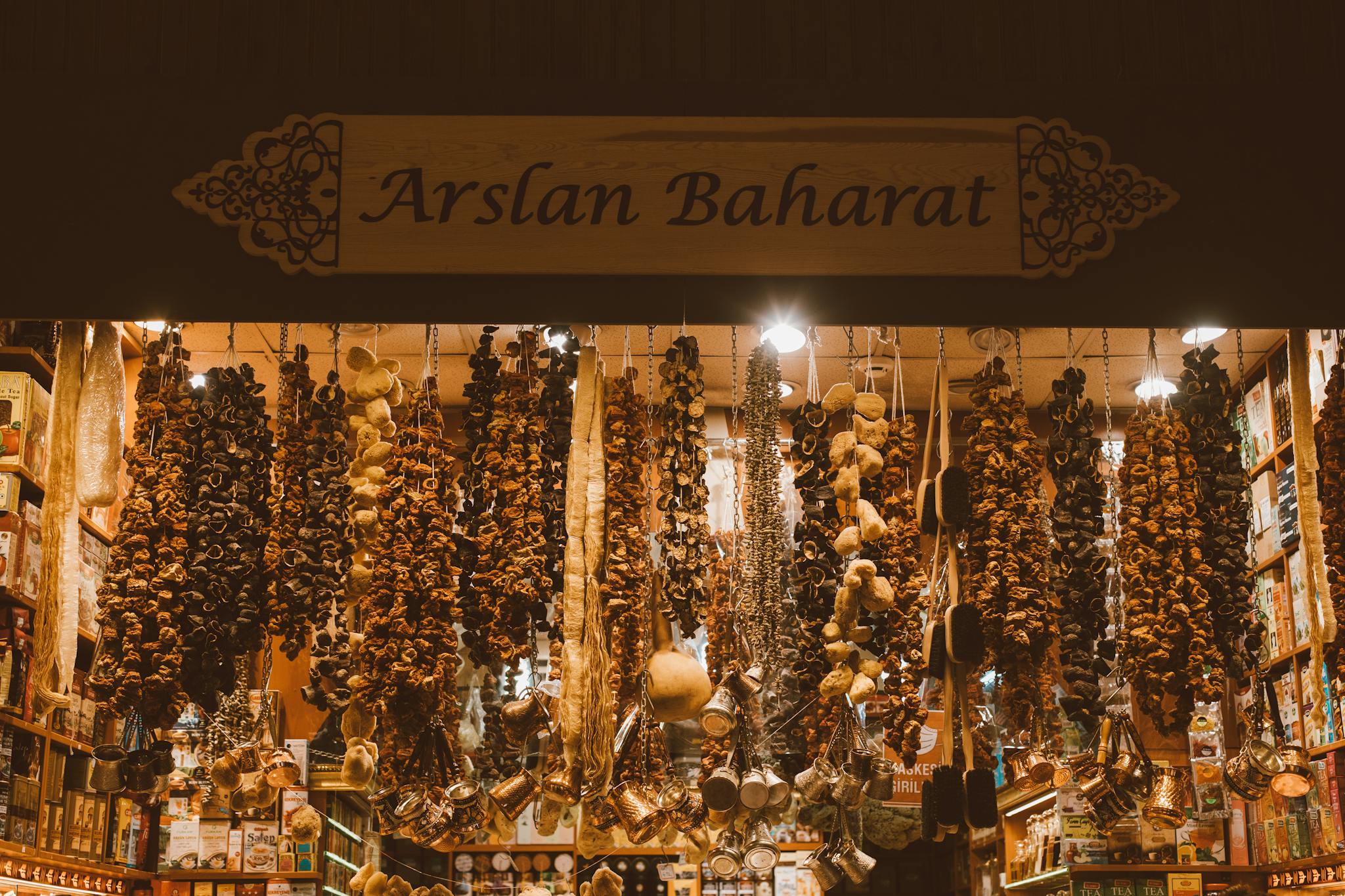 An array of dried spices and herbs hanging in a traditional spice market stall, creating a rich and aromatic scene.