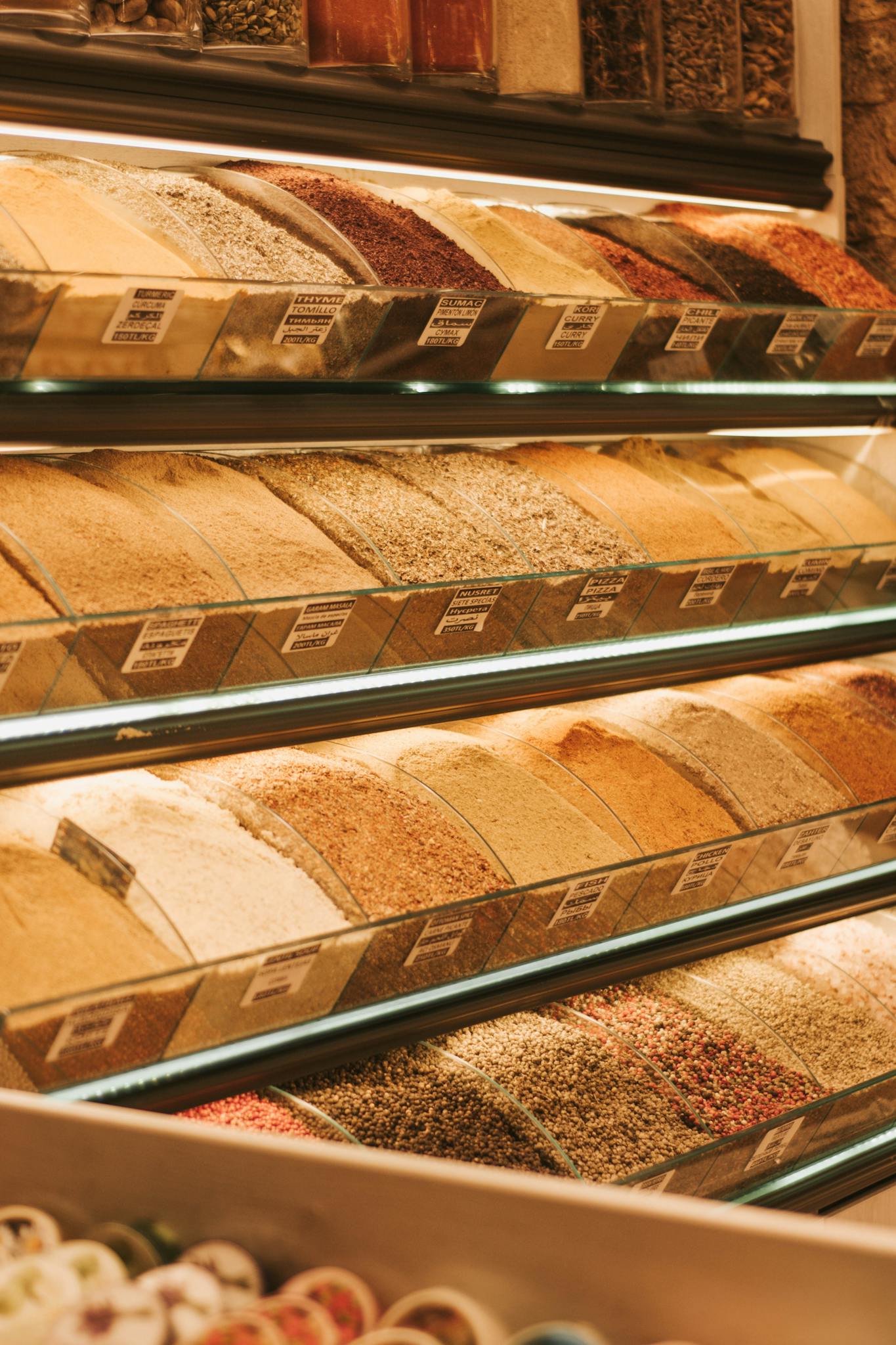 An array of grains displayed in an organized manner at a market stall indoors.